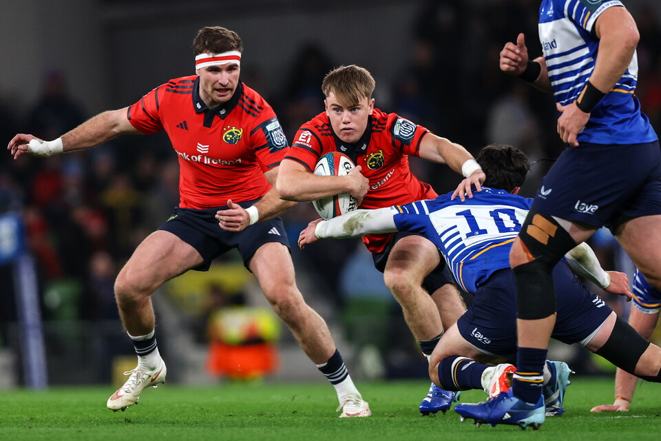 Players in red and blue jerseys run with the ball during a rugby match.