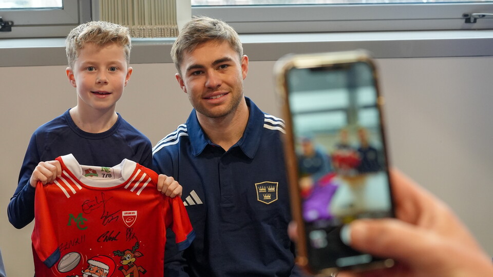 A photo of Jack Crowley with a young Munster Rugby supporter. 